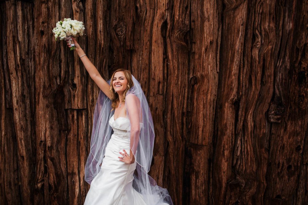 Bride holds her bouquet overhead during a portrait session