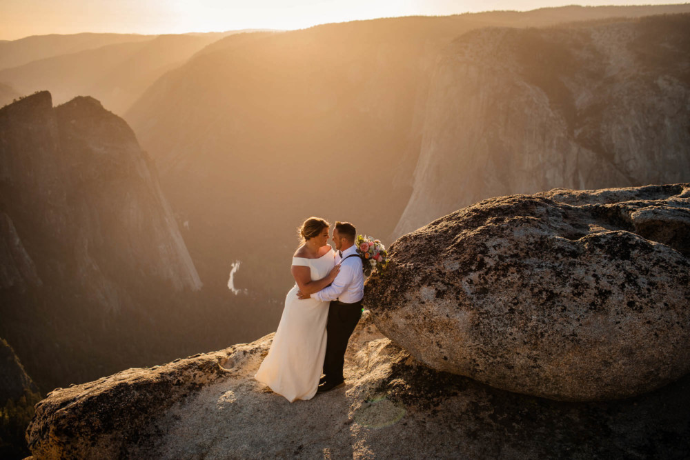 Bride and groom share a moment overlooking Yosemite Valley at Taft Point