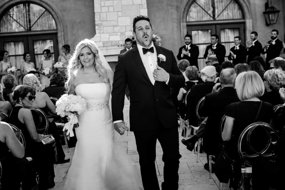 Groom lets out a big sigh as he walks down the aisle with his bride