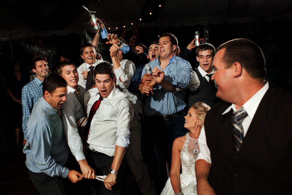 Single dudes fight for the garter at the wedding reception