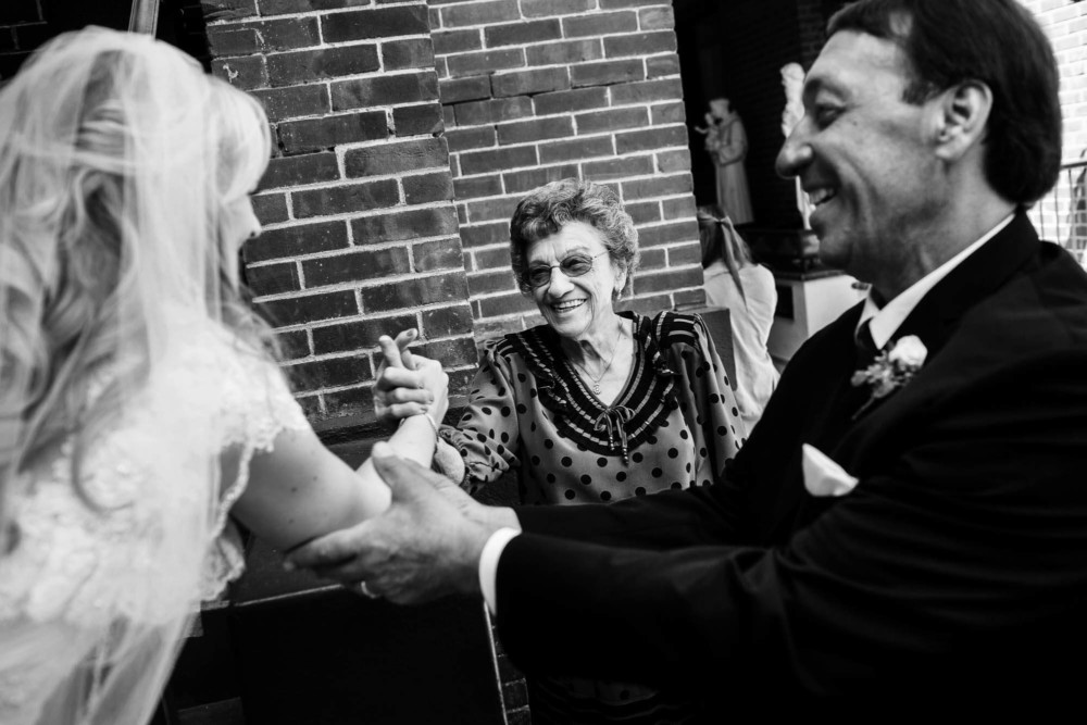 High five between grandma, father of the bride and the bride after her wedding ceremony
