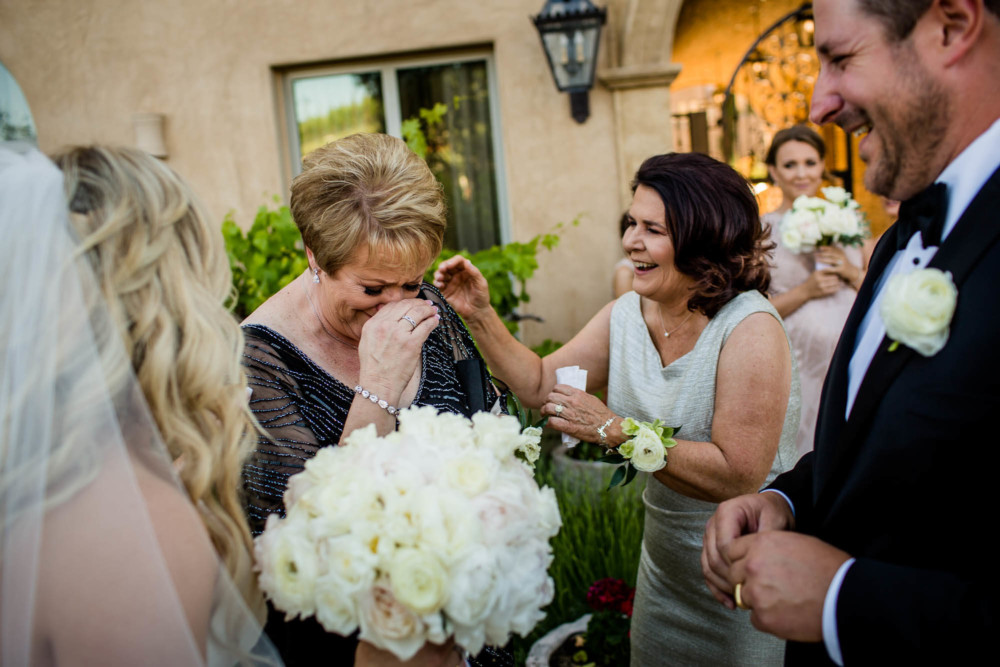 Mother of the groom starts to cry after her son gives her a gift after the wedding ceremony