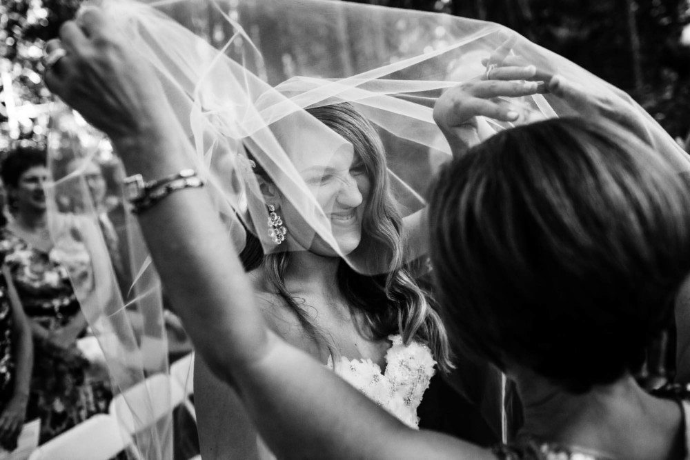 Bride's mother lifts her veil at the start of her wedding ceremony