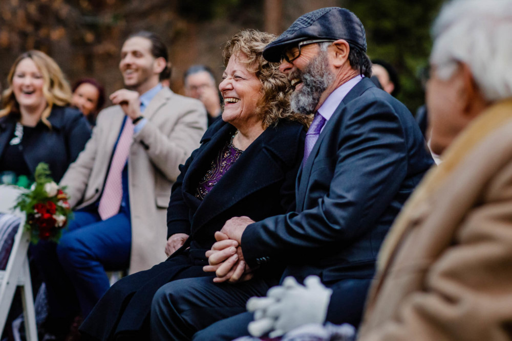 Mother and father of the bride react with laughter during the wedding reception