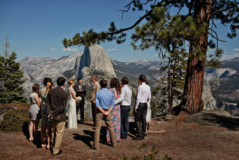 Bride and groom being married at Glacier Point looking across the valley to Half Dome