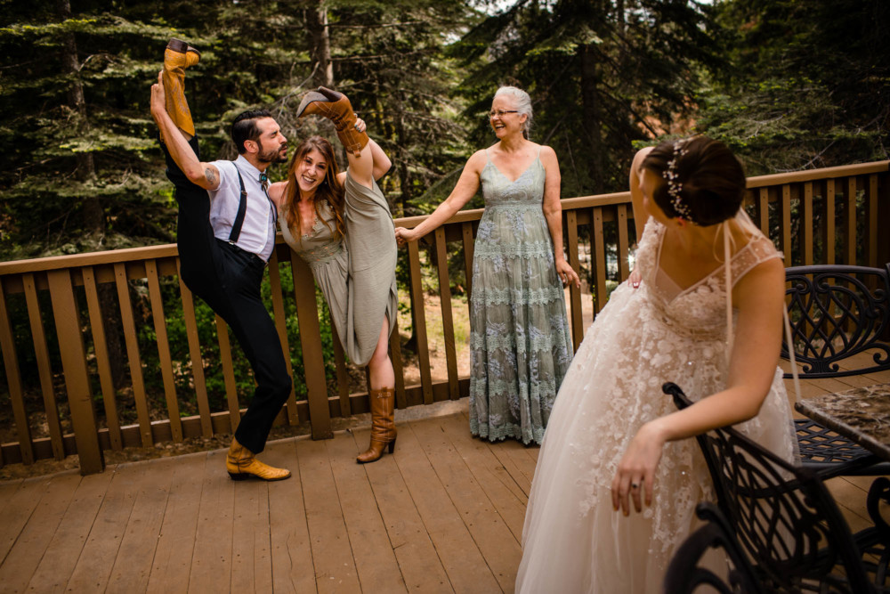 Bride laughs as her dancer friends stick their legs up in the air