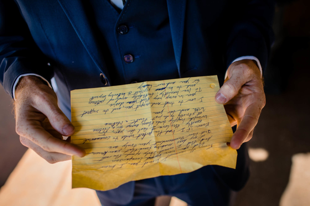 Groom reads over his handwritten vows