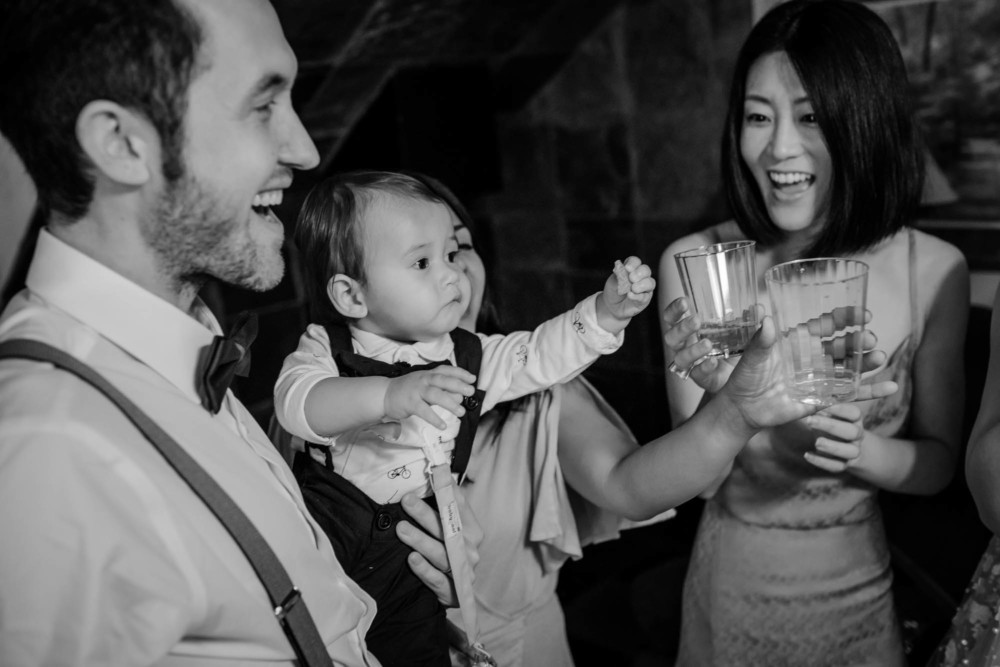 Baby toasting mom's champagne with a cookie