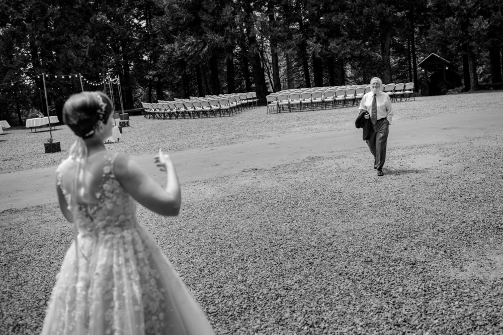 Bride's father walks across an empty field towards his daughter