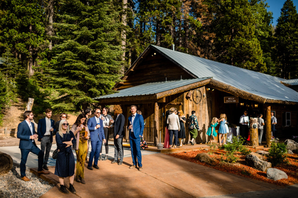 Guests mingle outside a cabin at a wedding reception