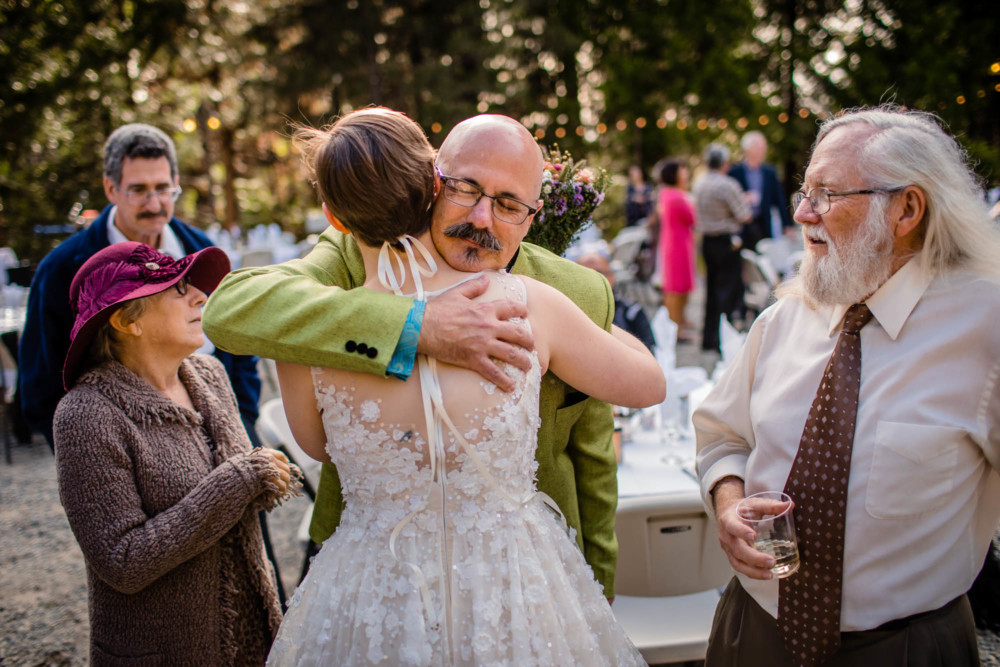 Bride gets hugs from guests at her wedding reception