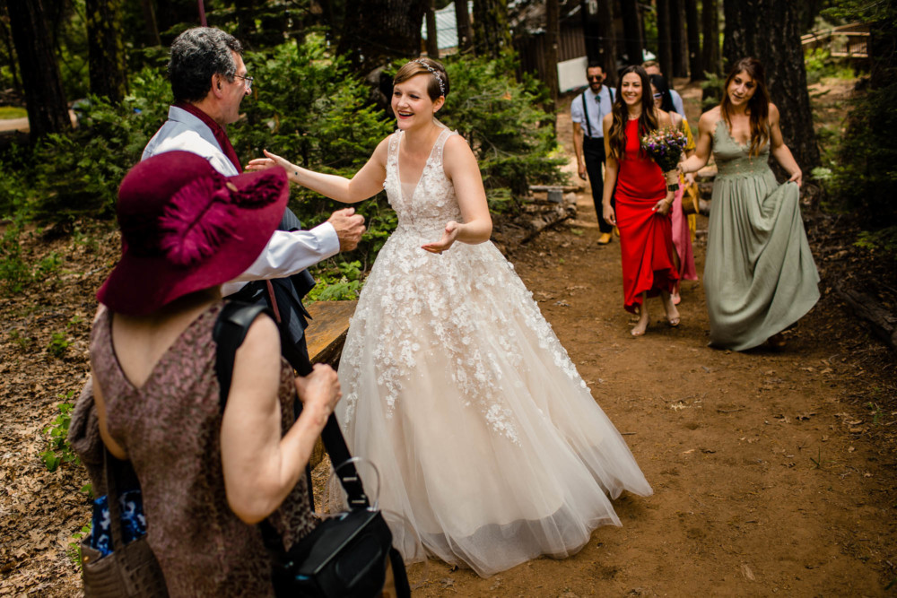 Bride greeting guests on a path near Paradise Springs