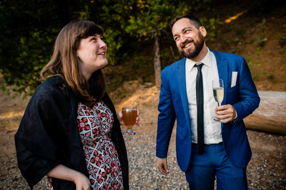 Guests share a laugh and a drink at a wedding reception