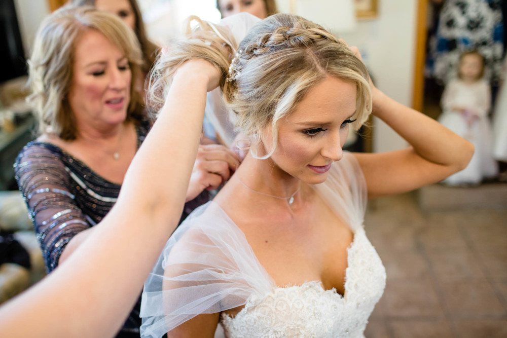 Mother of the bride helps her with her jewelry