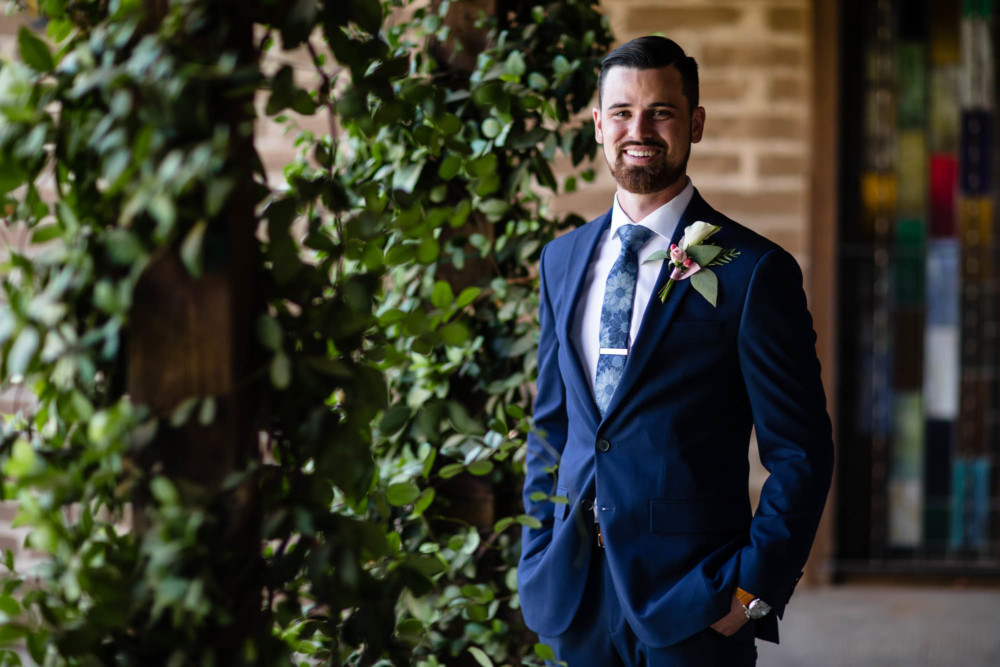 Portrait of a groom in a brick courtyard