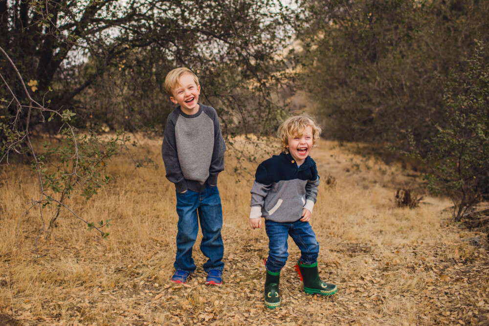 Two boys laughing during a family portrait session in the mountains