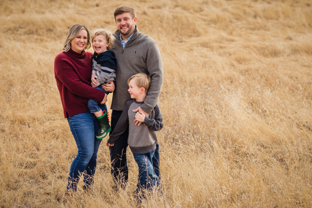 Family in sweaters in a golden grassy field